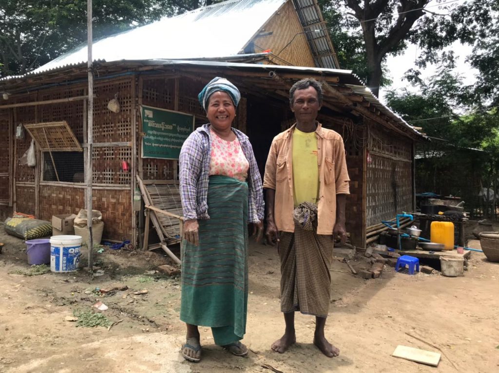 Farmer couple in front of their house in Myanmar