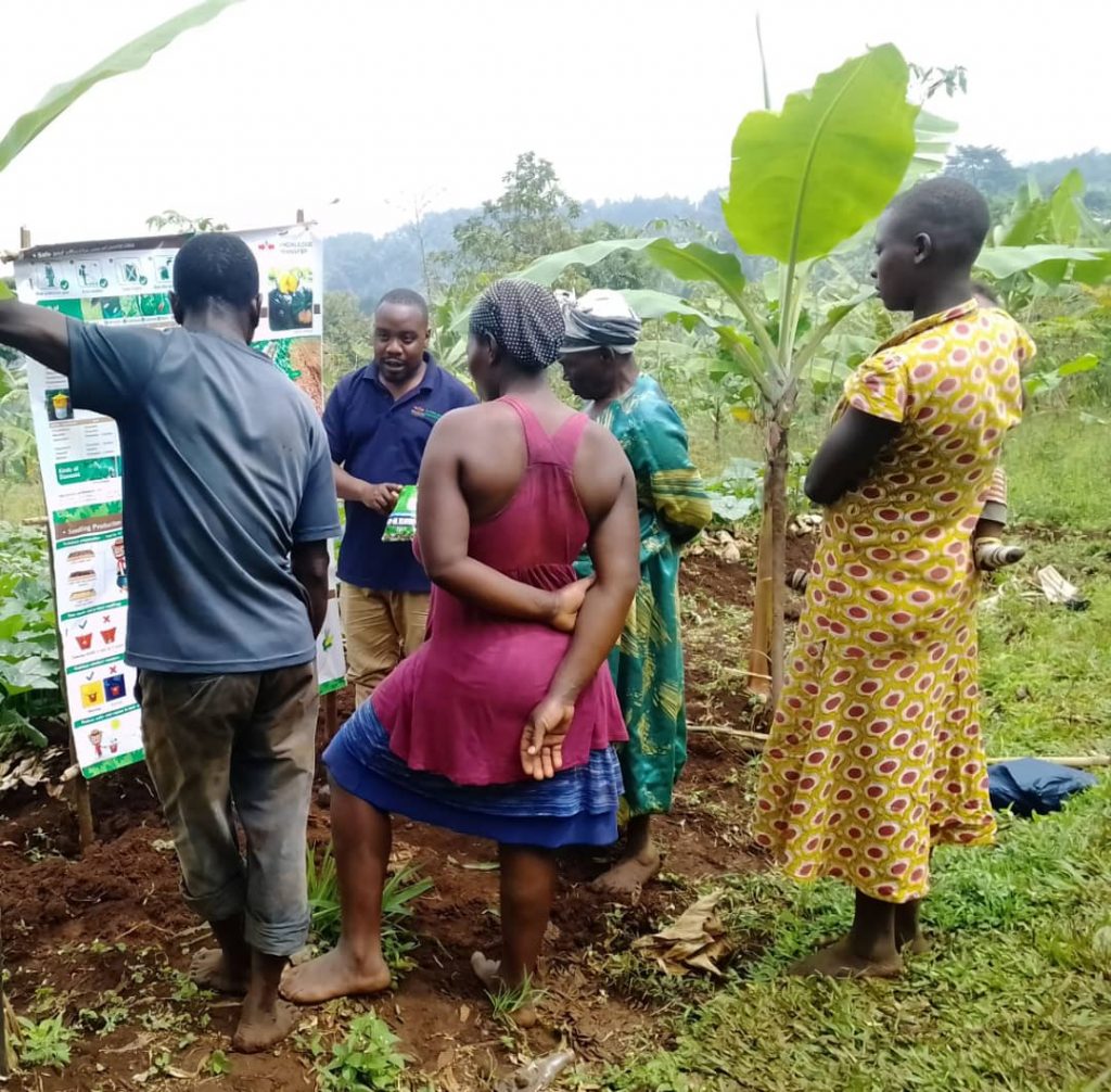farmers learning from a signboard during a training in Uganda