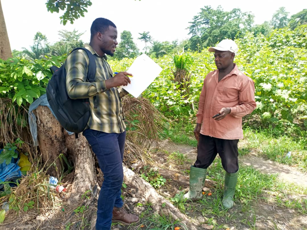 Francis Agyarko Asante interviews a farmer in his field