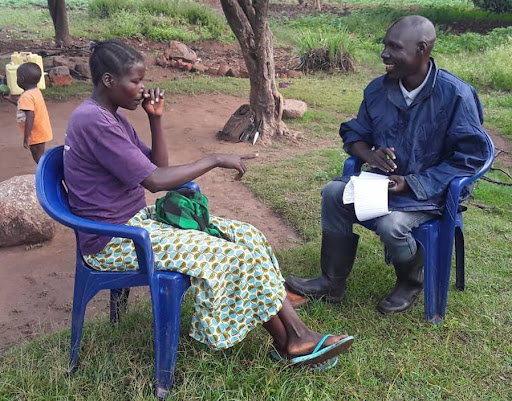 Uganda Technical Field Officer interviewing a woman farmer