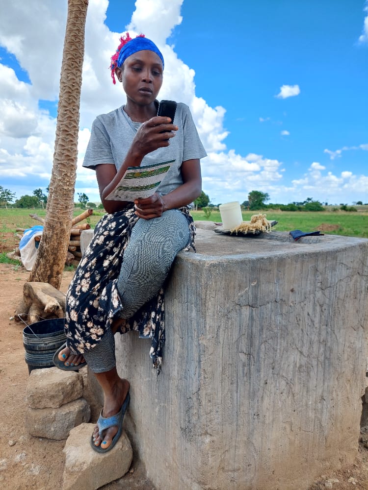 Tanzanian farmer Mariam Pius accessing learning resources on her mobile phone