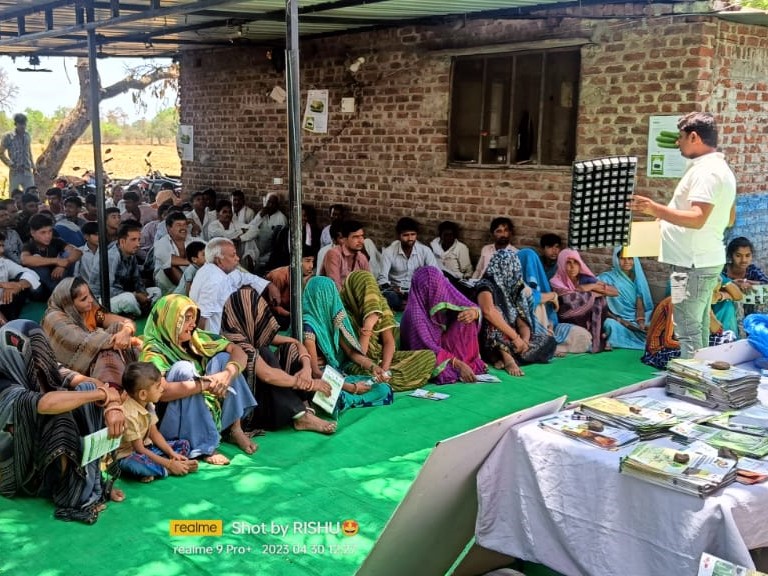 EWS-KT staff member trains group of male and female farmers on seedling production