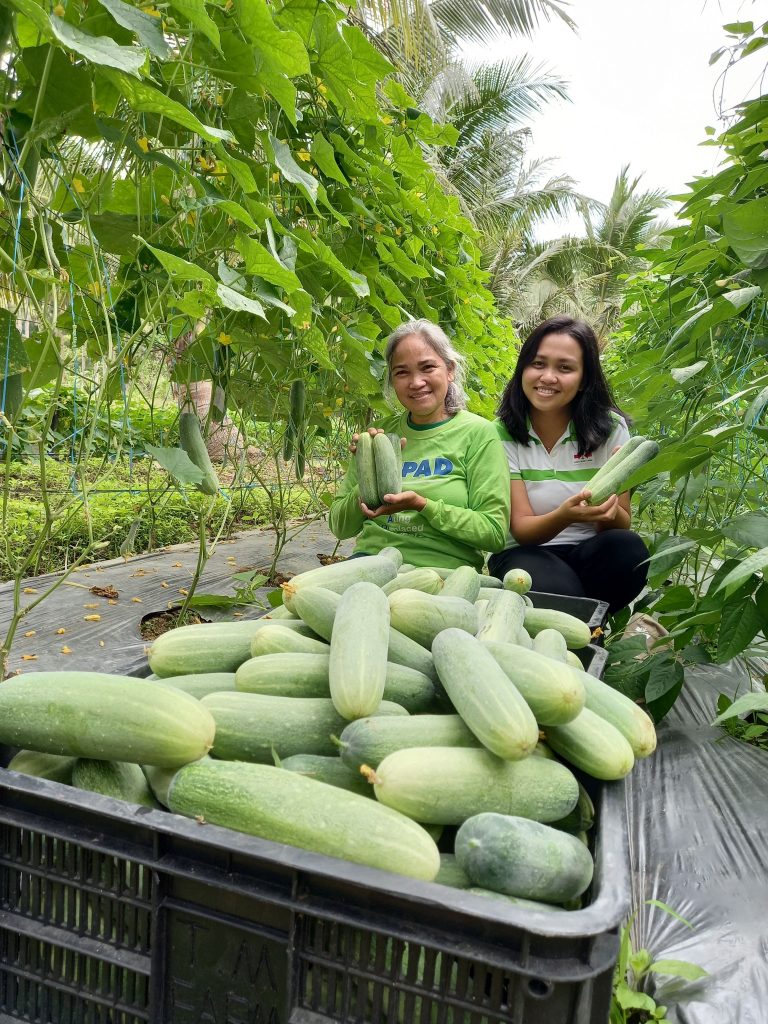 Marisol Abalora and Melody Atanoza with crates of cucumbers.