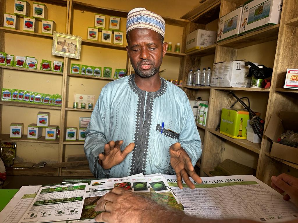 Sani Umar stands at the counter in his agro-input shop.