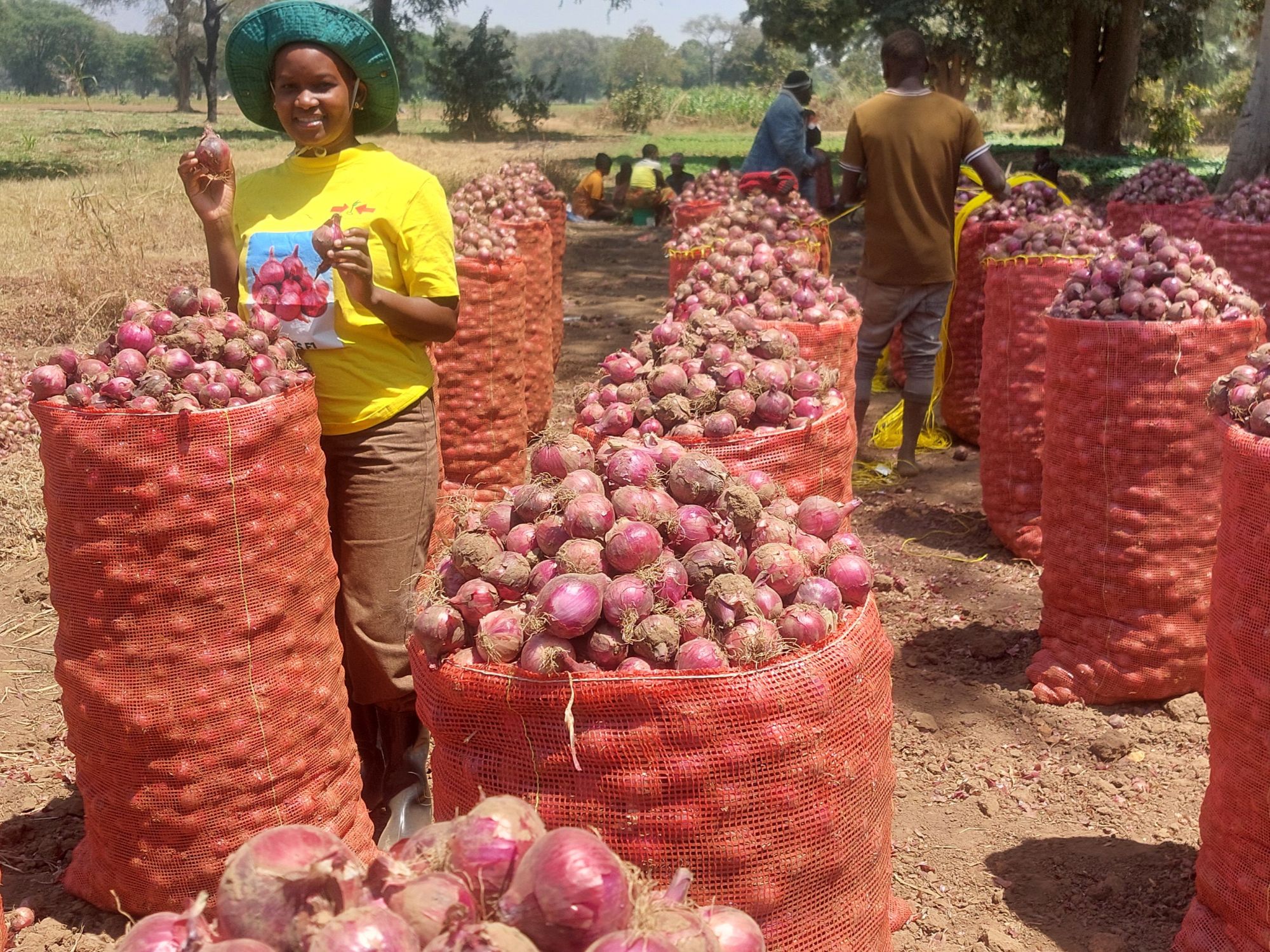 Woman with large sacks of red onions.