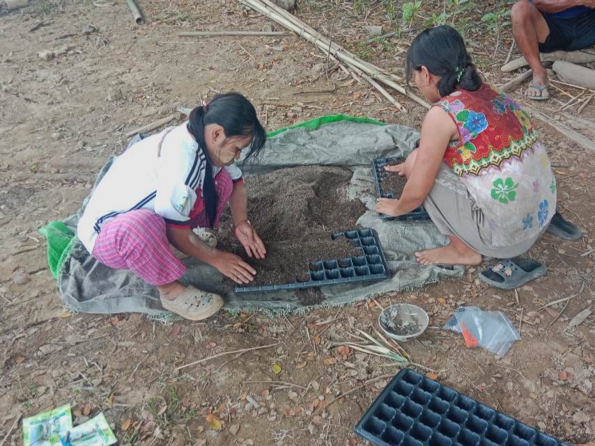 Students trained by EWS-KT share seedling techniques for home gardening.