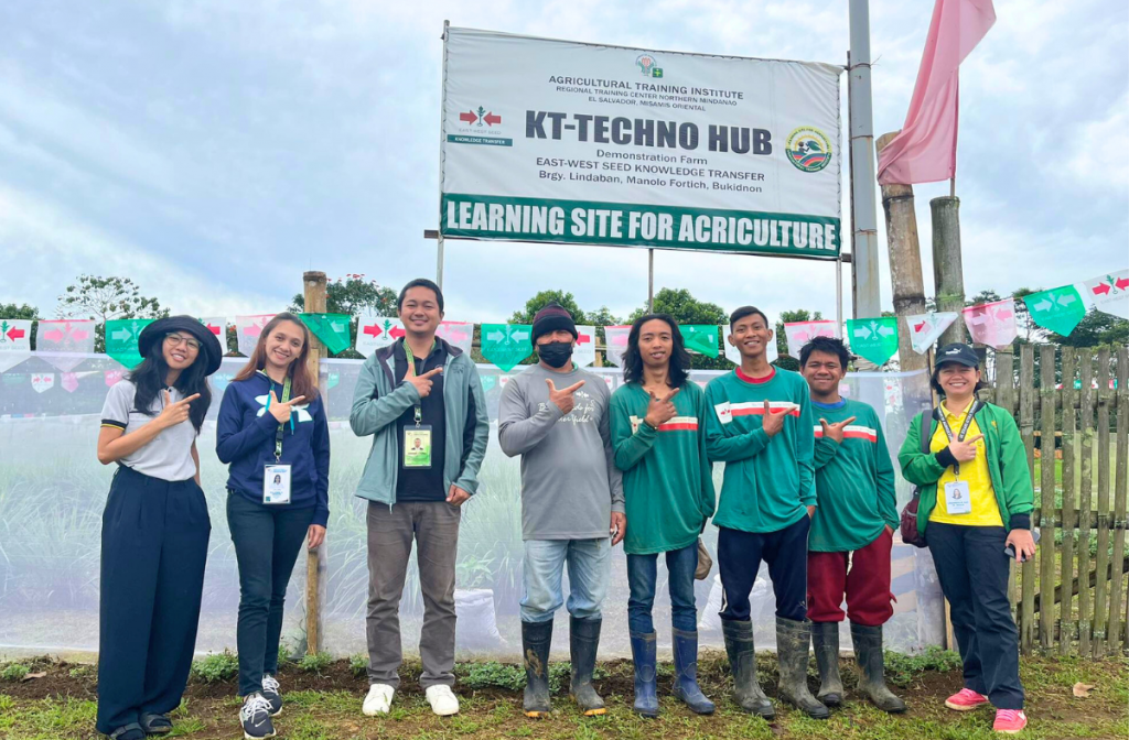 EWS-KT Philippines staff members celebrate in front of the KT-Techno Hub learning site sign