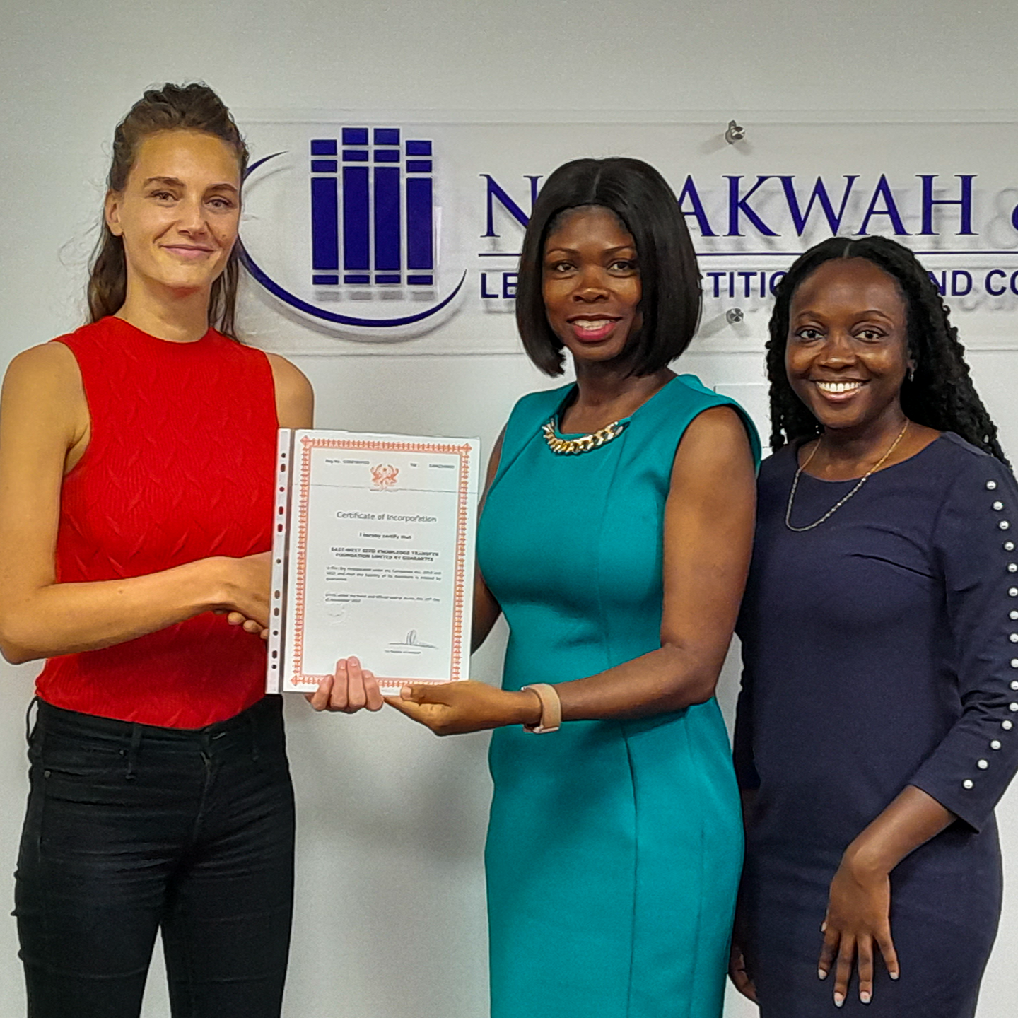 EWS-KT Program Manager Femke de Jong receives the registration document from Abena Ntrakwah-Mensah and Courtney Heather Awotwi of Accra law firm Ntrakwah & Co.