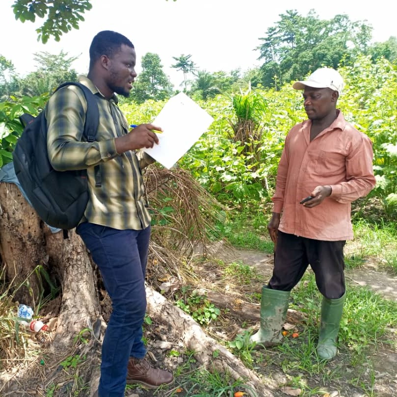 Francis Agyarko Asante interviews a farmer in his field.