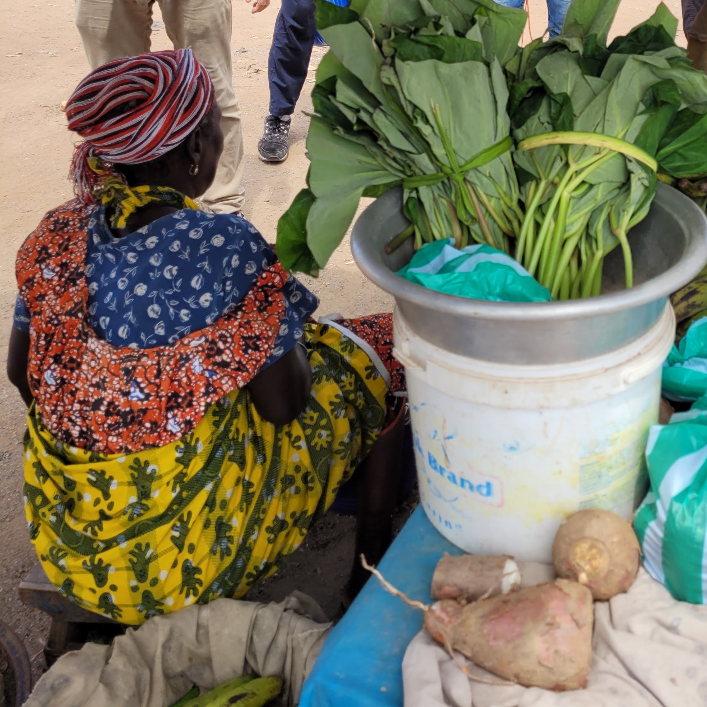 A woman selling greens at a market in Ghana.