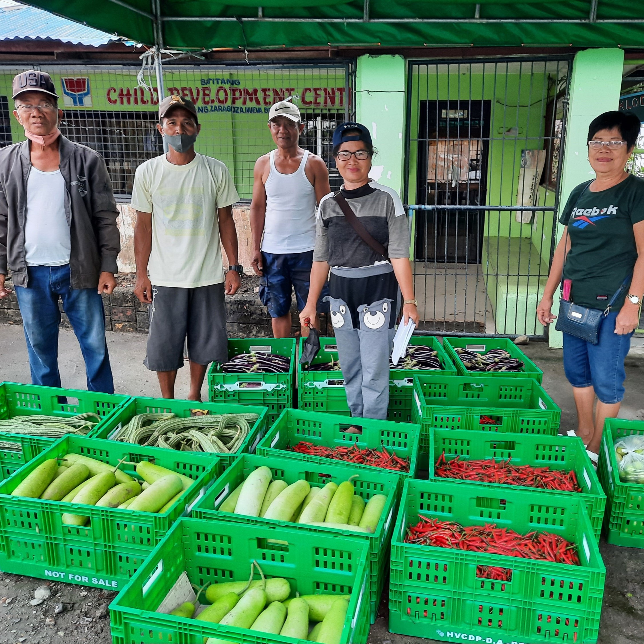 Rice farmers in Zaragoza, Nueva Ecija, stand with crates of fresh vegetables.