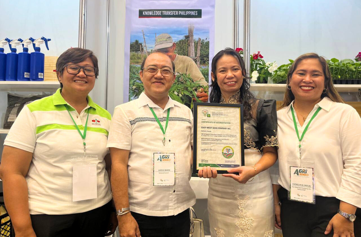 EWS-KT Philippines staff stand with Luis D. Bausa, the Private Sector Representative on the ATI PAF-ESP Accreditation Council. EWS-KT Philippines Knowledge Transfer Manager Girlie Frando holds the certificate of accreditation.