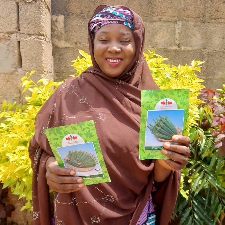 Aisha Yusuf holds up packets of okra seeds.