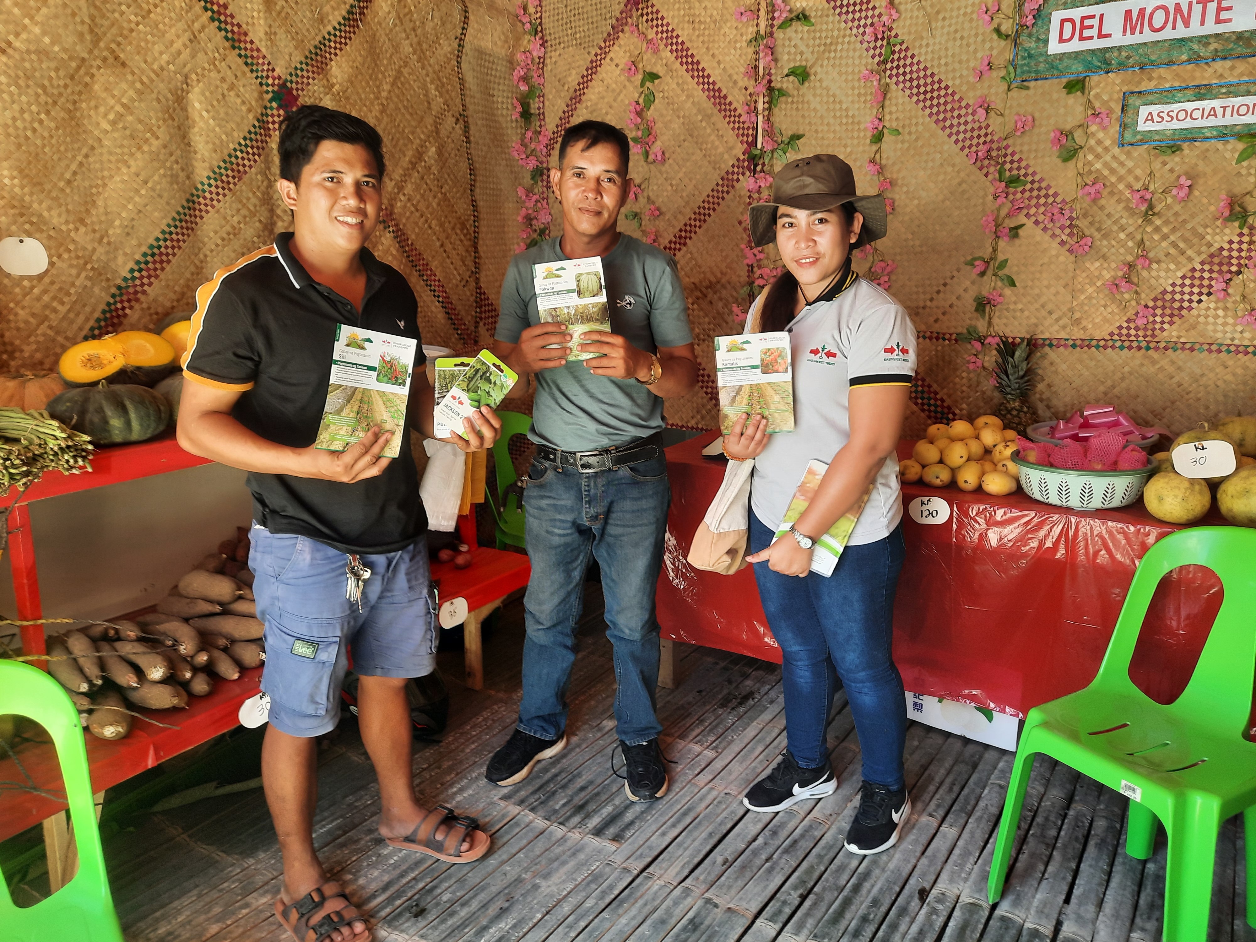farmers stand with printed crop guides in a shop