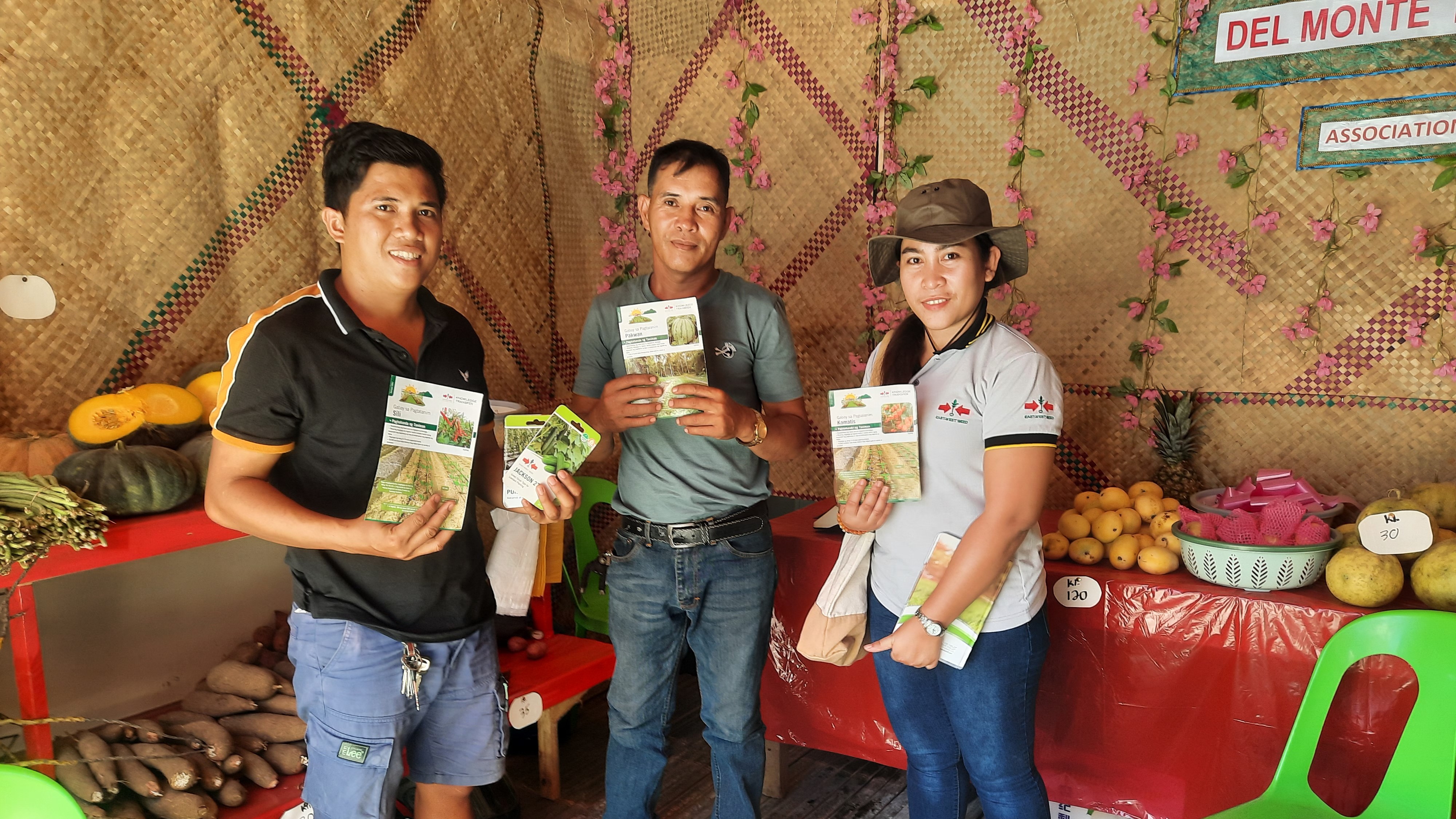 farmers stand with printed crop guides in a shop