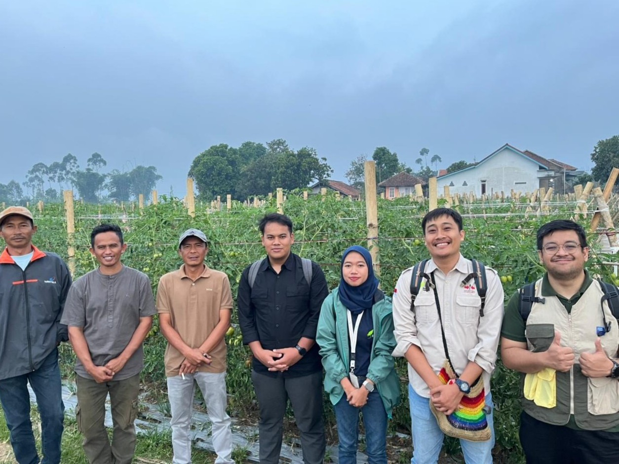 Yayasan Bina Tani Sejahtera staff for the project in front of a field.