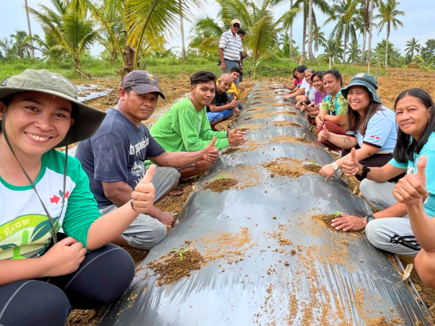 Farmers at a training practice transplanting into a raised bed.