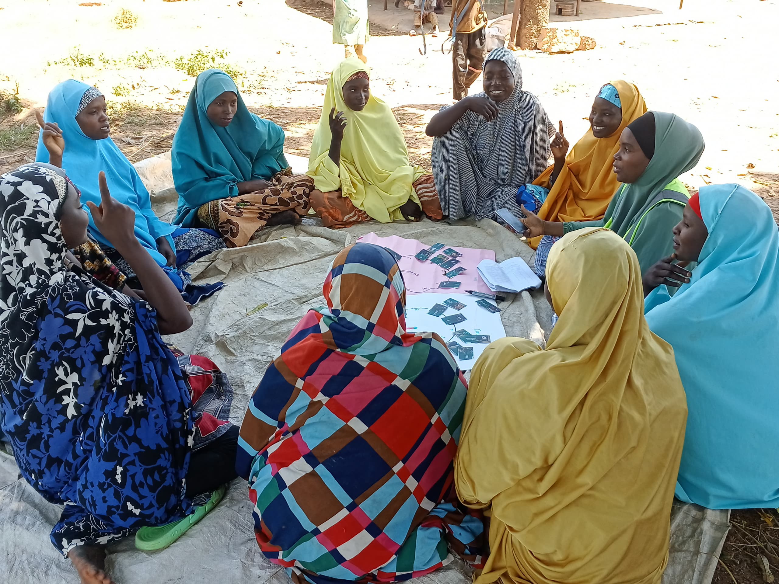 Women farmers sit in a circle while participating in a focus group discussion.