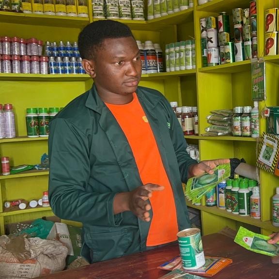 Musasizi Moses behind the counter in his agro-input shop,