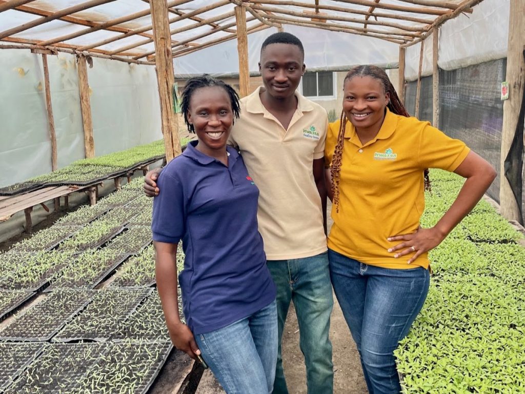 Mwaisa Seedling Centre owner and staff member with EWS-KT Team Lead Virginia Kisimbe inside a seedling nursery at Mwaisa Seedling Centre.