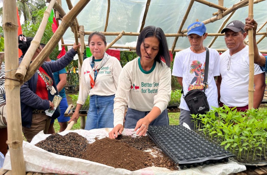 Women key farmers lead a seedling production demonstration at the technical field day.