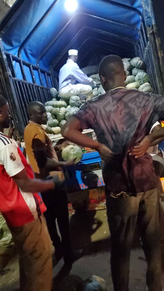 Trader Kakoza Dirisa selects pumpkins from the back of his truck.
