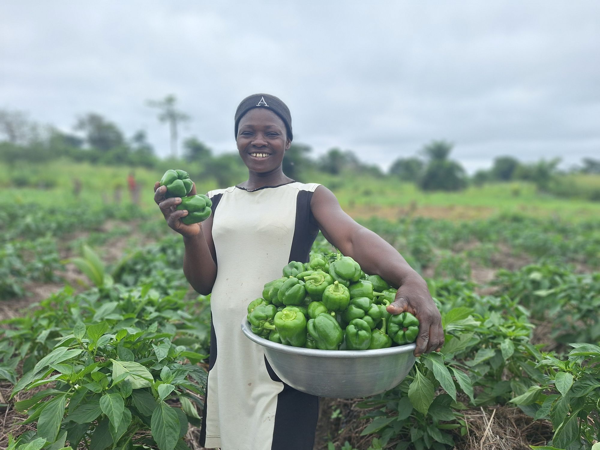 Female farmer with basket full of peppers.