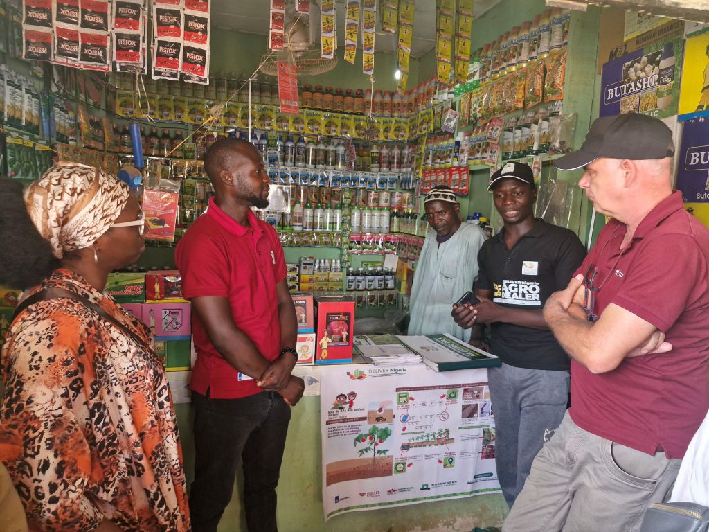 Agro-input dealer Umar Abubakar talks with visitors in his shop.