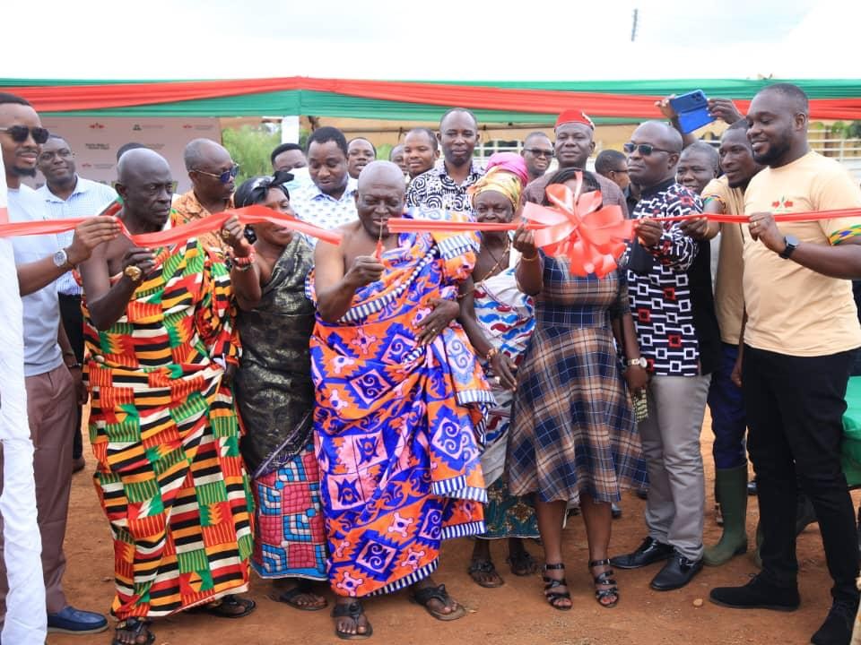 Standing with a large group of visitors, Nana Bonsu, chief of Duayaw Nkwanta, cuts the ribbon to open the learning farm.