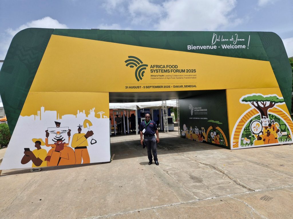 Epaphras Milambwe, Knowledge Transfer Manager for Tanzania, in front of the Africa Food Systems Forum 2025 entrance.