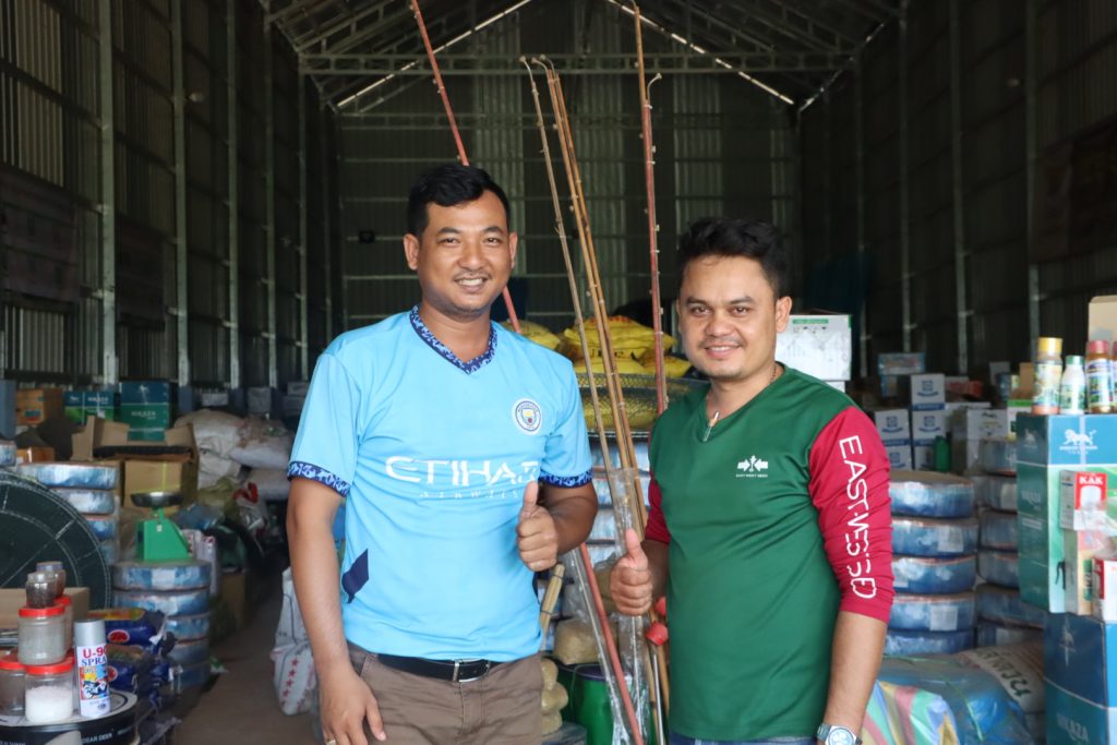 Cambodian agrodealer Soeum Dina with EWS-KT Technical Field Officer Yoeum Phalla in a storage area for Dina's shop.