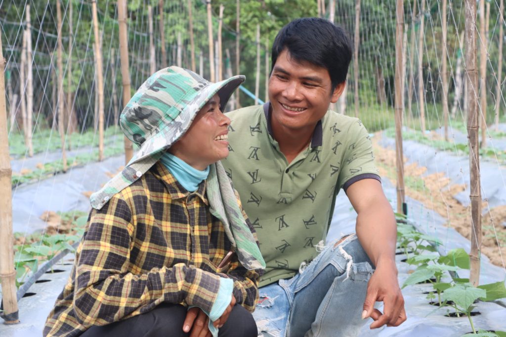 Cambodia farmers Lok Thary and Moul Thea between rows of young cucumber plants.