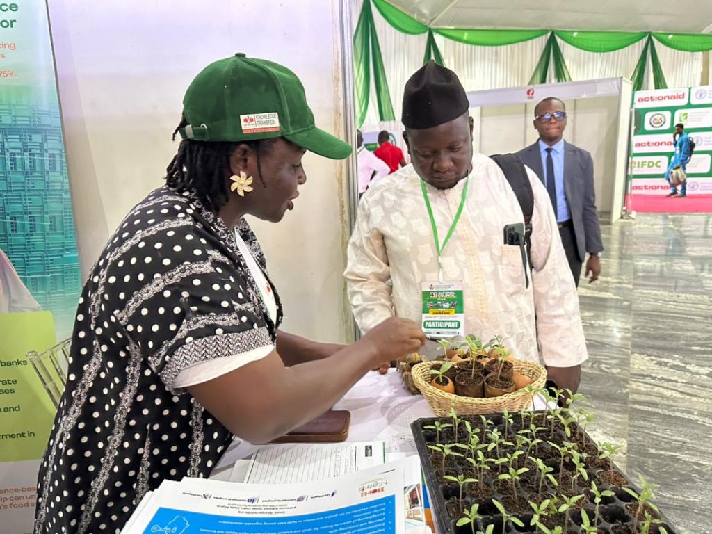 A visitor to our booth at the 47th National Council on Agriculture and Food Security (NCAFS) admires the seedlings on display.