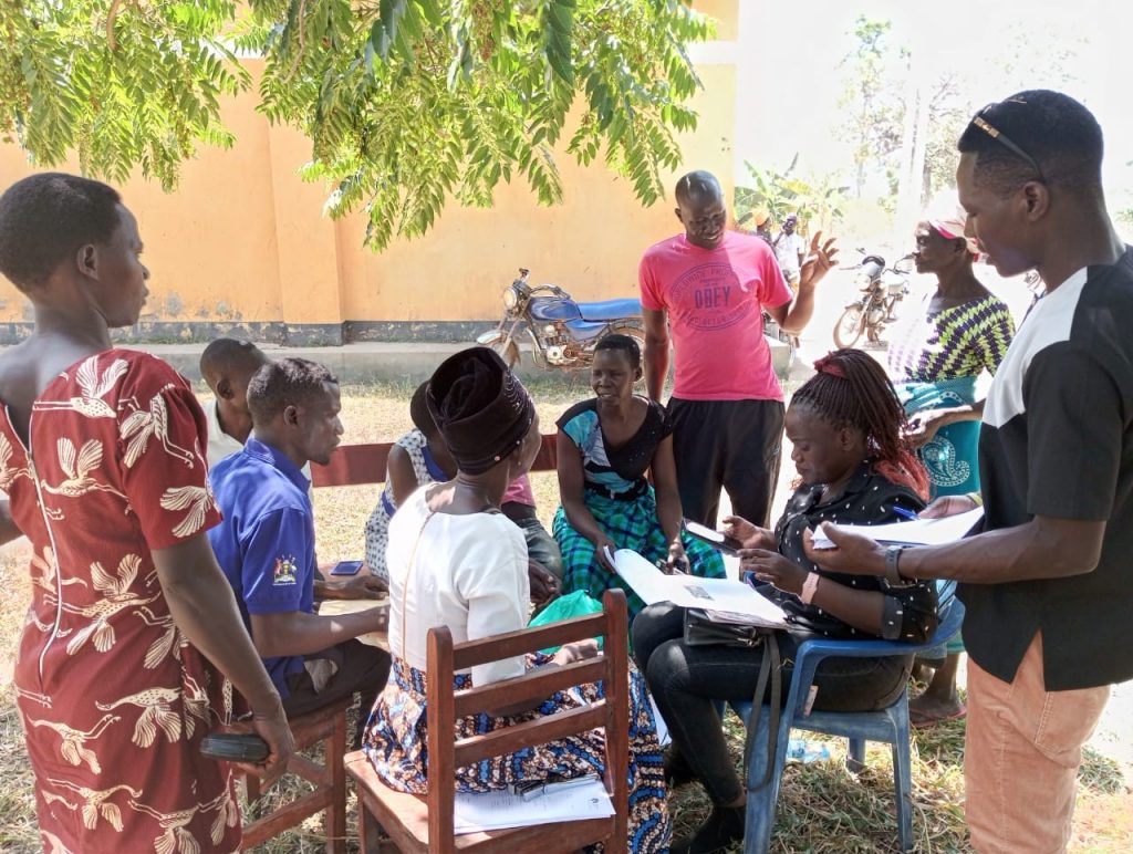 Centenary Bank staff help farmers with the paperwork for establishing bank accounts.