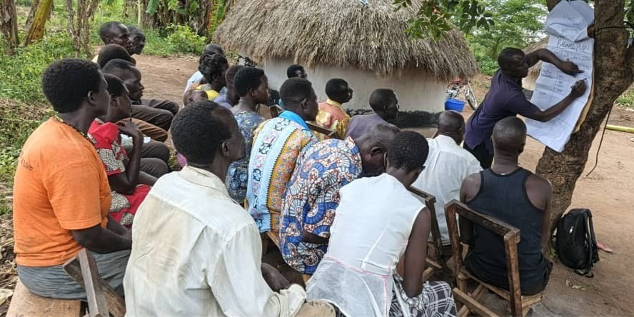 Farmers attend an outdoor training on estimating and calculating farm costs and returns.
