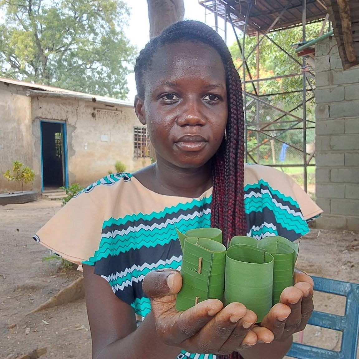 South Sudanese student and farmer Gloria Hibba Juma holds leaf pots she has made.