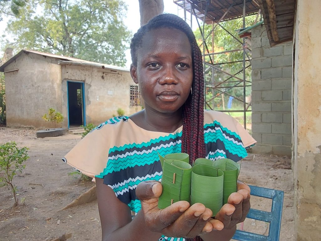 South Sudanese student and farmer Gloria Hibba Juma holds leaf pots she has made.