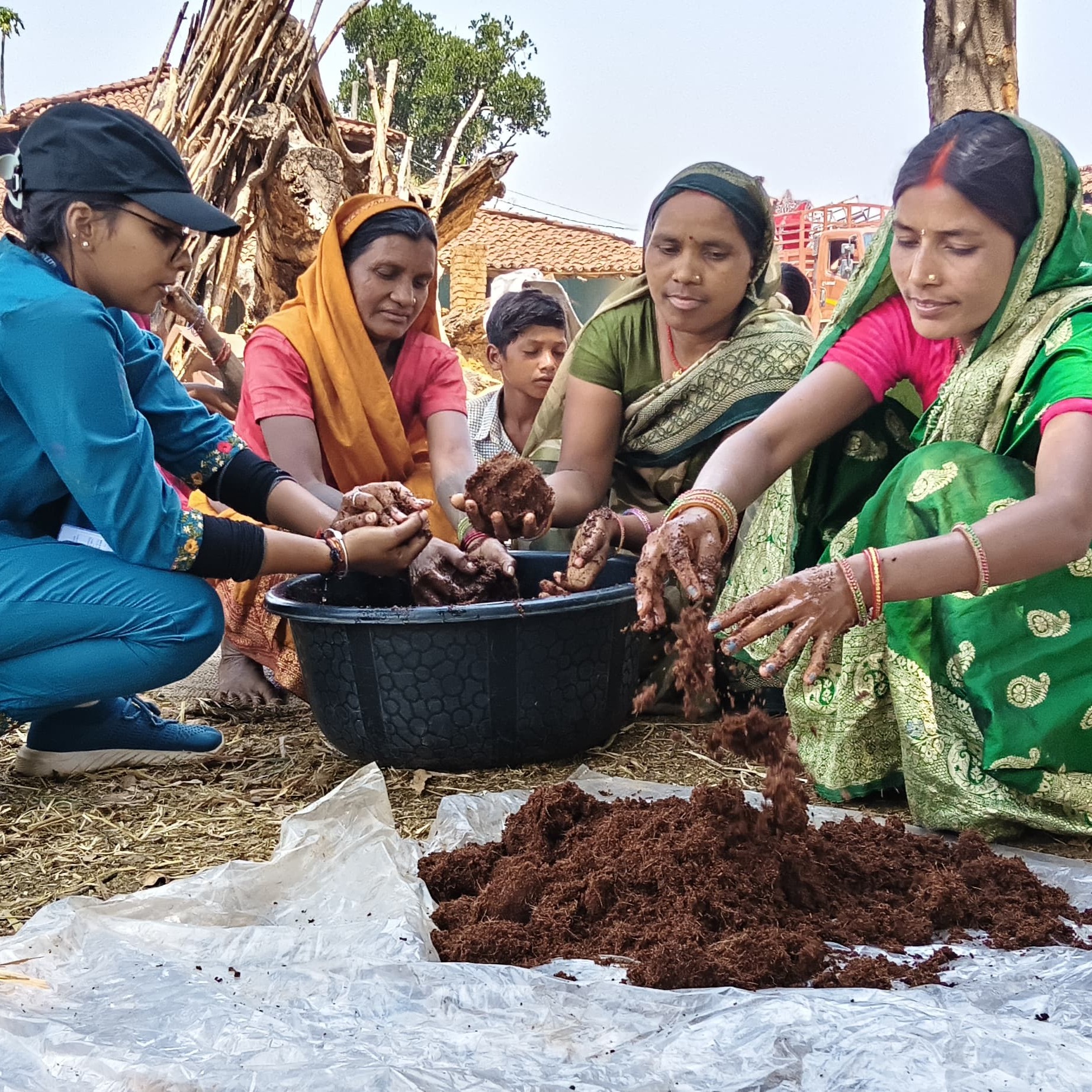 Guided by a staff member from East-West Seed Knowledge Transfer Foundation, smallholder female farmers in Chhattisgarh, India, prepare the medium for growing hot pepper seedlings.
