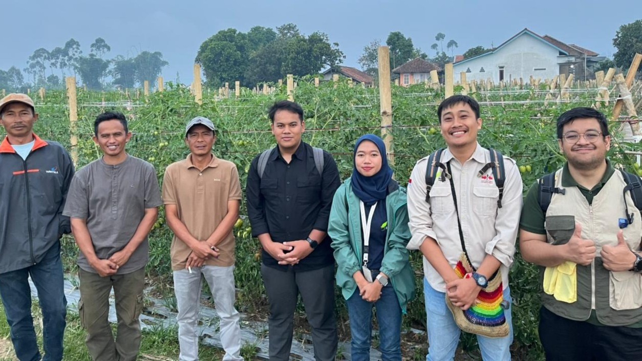 Yayasan Bina Tani Sejahtera staff for the project in front of a field.