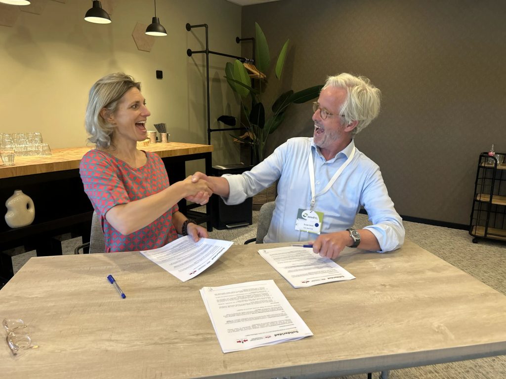 Heske Verburg, Managing Director of Solidaridad Europe, and Rutger Groot, Board Chair of East-West Seed Knowledge Transfer Foundation, shake hands after signing a collaboration agreement between the two organizations.